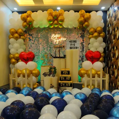 This "Better Together" setup is perfect for anniversaries or romantic celebrations. It features a stunning arch of gold and white balloons, a shimmering backdrop, and red heart accents to symbolize love.