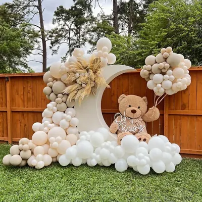 This outdoor teddy bear baby shower is a perfect example of a chic, modern take on a classic theme. The neutral-toned balloon garland, pampas grass accents, and a large teddy bear on a moon crescent create a stunning focal point.