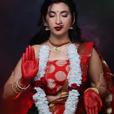 Embodying the divine feminine energy in this goddess-themed shoot. The makeup features a strong red bindi, bold red lips, and expressive eyes, complemented by traditional attire and alta on the hands.