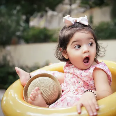 That look of pure surprise! This candid shot of a toddler in an outdoor setting perfectly captures the spontaneous and expressive nature of little ones.