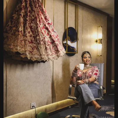 This picture is so me. Enjoying a quiet moment with a cup of chai, dressed casually, with a grand bridal lehenga I'm working on right beside me. It perfectly captures my love for both comfort and high fashion.