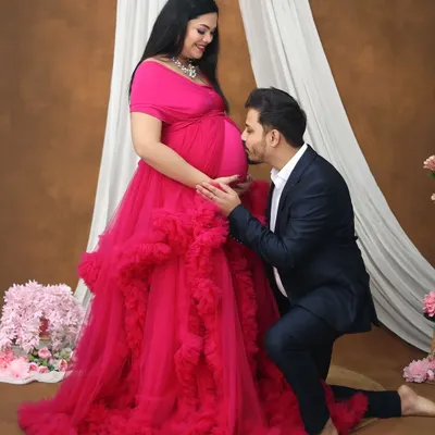 A tender moment as the dad-to-be lovingly kisses the baby bump. This pose is a client favorite, beautifully capturing the bond between the couple and their unborn child in our studio.