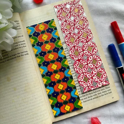 A pair of vibrant, handmade bookmarks featuring intricate geometric patterns. The one on the left has a colorful floral-inspired design, while the one on the right uses a classic red and gold combination. Custom orders are always welcome.