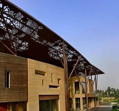 The Tree House's most striking feature is its expansive, perforated metal roof, supported by columns that branch out like trees. This canopy not only defines the home's aesthetic but also functions as a climate control element, shading the structure from the harsh sun.