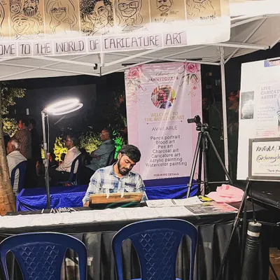 My complete live caricature setup at a night market, with my banner, ring light, and examples of my work on display. I'm always ready for any event.