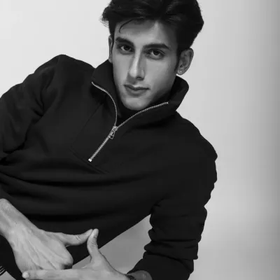 A classic black and white portrait. Stripping away the color allows the focus to be entirely on the model's expression and the clean lines of his pullover.