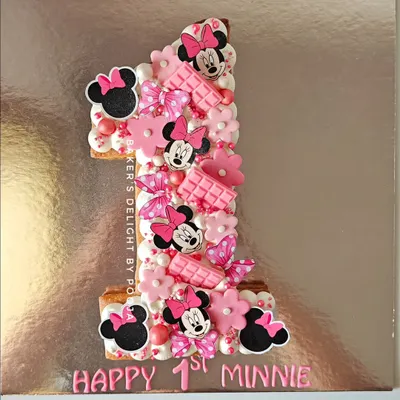 One in a Minnie! This number "1" shaped tart cake was a magical way to celebrate a first birthday. The butter tart base is filled with chocolate mousse and decorated with adorable Minnie Mouse details.