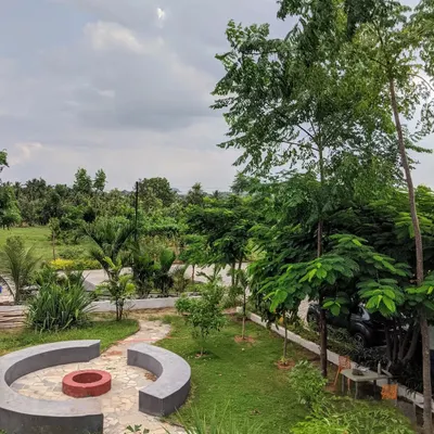 An overhead view of a spacious garden featuring a custom-built circular fire pit and seating area. This design creates a natural gathering spot within the larger landscape for friends and family.