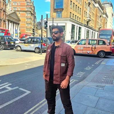 A full-length shot on a street in London's financial district. This demonstrates a confident, modern look suitable for urban fashion, travel, or lifestyle brand campaigns.