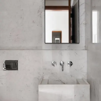 This bathroom features a custom vanity and sink I sculpted from a single block of marble. The design is minimalist and monolithic, showcasing the beauty of the natural stone and my focus on precise craftsmanship.