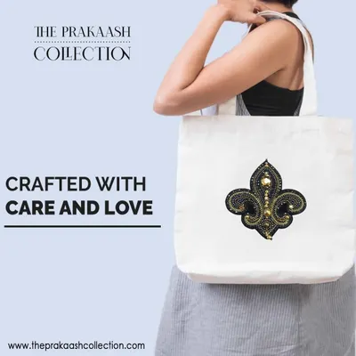 A plain white tote bag is transformed with a hand-embroidered, stone-studded fleur-de-lis patch. This shows how a simple appliqué can add a touch of character and fashionable flair to an everyday accessory.