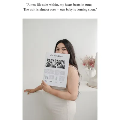 A creative and sweet announcement. This mother-to-be holds a custom "Baby Times" newspaper, sharing her exciting news with a beautiful smile in a bright, minimalist setting.