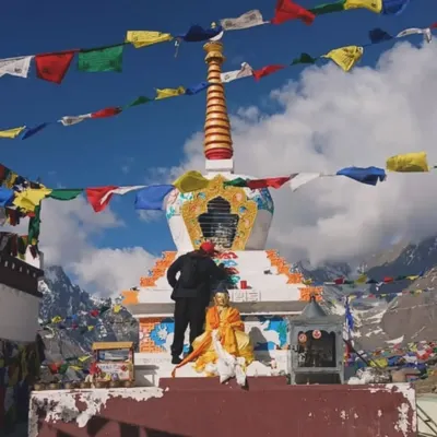 An unforgettable experience assisting a local artist to paint a Stupa at Kuncham Pass, situated 15,000 feet above sea level. This wide shot shows the scale of the stupa against the vast, snowy mountain landscape.
