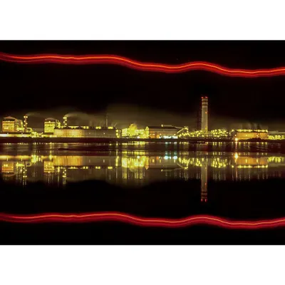 A night-time long exposure of a factory complex. The perfect reflection on the water and the creative light streaks make this a standout piece of artistic industrial photography.