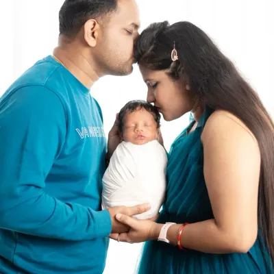 The first family photo. This image captures the tender moment when new parents hold their baby together, marking the beautiful beginning of their journey as a family.