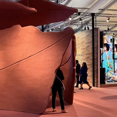 A visitor finds a moment of quiet contemplation within the sweeping curves of our 'Terra' installation. The piece is a visual poem about leaves, rendered in abstract forms to capture the feeling of shedding and returning to the earth.