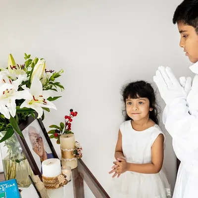 It was an honor to document Rehaan's Holy Communion. Here, he and his sister share a quiet moment by a memorial for a loved one, a poignant part of their family's story on this important day.