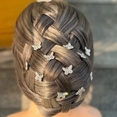 This intricate basket-weave bun is a testament to the advanced skills taught in our hairstyling course. We focus on creating clean, precise patterns and adding delicate accessories like these butterfly clips for a fairytale finish.