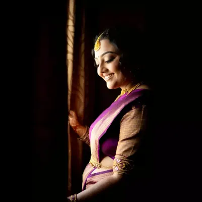 An artistic bridal portrait using shadows and light to create a sense of mystery and elegance as she gets ready.