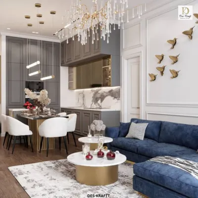 A complete view of this open-concept living space, showing how the plush blue sofa, marble tables, and elegant dining area coexist harmoniously under a stunning crystal chandelier.