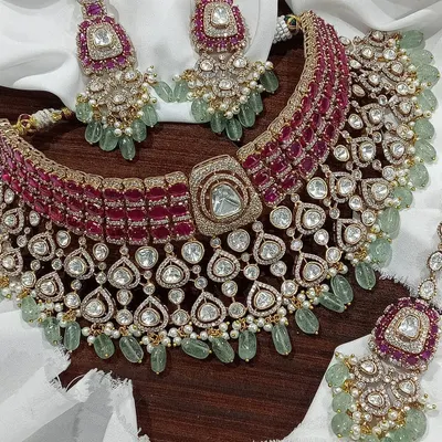 A masterpiece for your main event. This is our grand bridal choker set with deep ruby stones and contrasting mint-green beadwork, designed to give you a majestic look for your wedding ceremony.