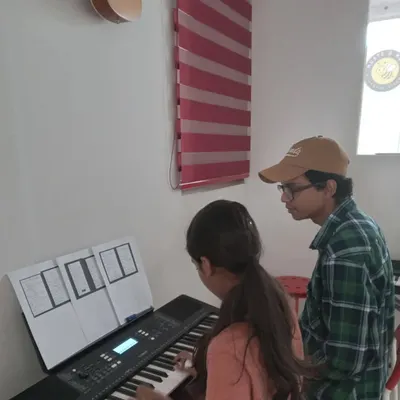 A student receives personalized guidance from her keyboard instructor. This individual attention is key to our teaching philosophy.