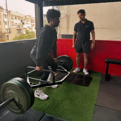 We believe in building strength from the ground up. Here, I'm guiding a client through a trap bar deadlift, ensuring perfect form to maximize power output and prevent injury.