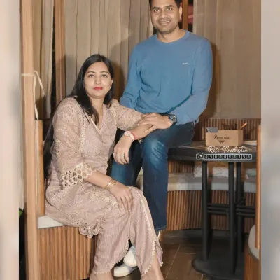 A posed portrait of a couple in a cafe setting, perfect for anniversaries or casual photoshoots.