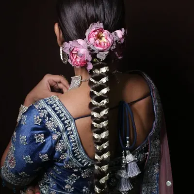 A stunning example of a traditional bridal braid, intricately woven with gota patti and adorned with fresh flowers. This is a key style covered in my advanced hairstyling course.