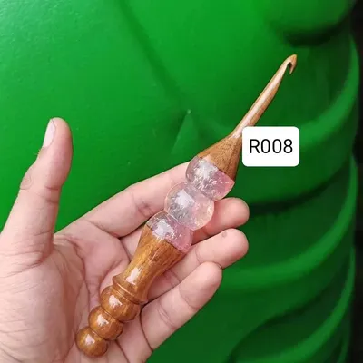 A close look at my hybrid hook with a pink and clear resin handle. The ergonomic shape is designed to fit perfectly in your hand, making long crochet sessions much more enjoyable.
