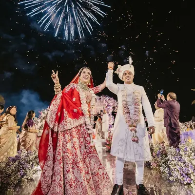 Pure joy as the couple jumps for a photo under a sky full of fireworks at their Thailand beach wedding. This shot perfectly captures the celebratory spirit of a destination wedding.