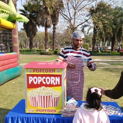 A popcorn machine on rent for a family day event. My operator serves fresh, hot popcorn to guests, adding a classic carnival feel to the celebration.
