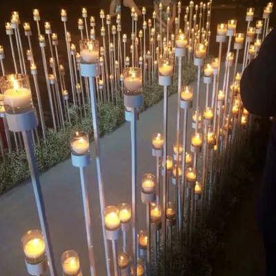 A beautiful pathway lined with dozens of candles at varying heights. This creates a magical, romantic, and dramatic entrance for an evening or night event.