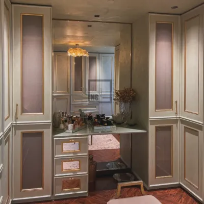 Here is a closer look at the built-in vanity inside a custom walk-in closet. The large mirror reflects the entire space, making it feel bigger, while the gold-trimmed drawers and elegant countertop provide a dedicated, well-lit area for getting ready.