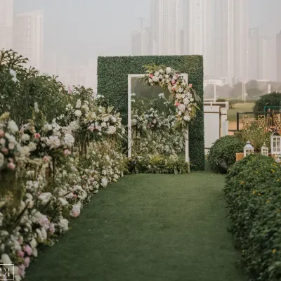 A chic, serene, and earthy entrance for a garden reception. Guests walked through a pathway lined with flowers to a mirrored doorway set in a hedge wall, creating a magical "secret garden" effect.