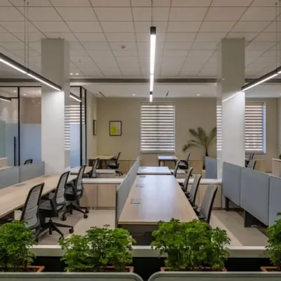 This open-plan office is designed for a modern workforce. We integrated planters into the workstation dividers to bring in nature, while the linear lighting and clean desk layouts create a sense of order and professionalism.