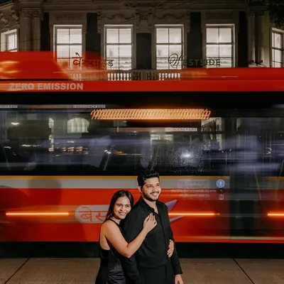 A couple shares a quiet moment as the vibrant energy of a Mumbai BEST bus streaks past. I used a slow shutter speed for this pre-wedding photograph to create a cinematic effect, freezing their connection amidst the city's constant motion.