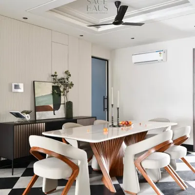 This dining space is a study in contrasts, designed to spark conversation. The sculptural base of the table, the gentle curves of the chairs, and the bold, graphic statement of the checkerboard floor come together to create a room with minimal yet dramatic presence.