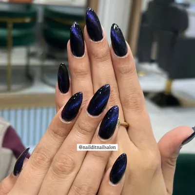 A perfect example of the cat-eye effect. We use magnetic polish to create a stunning blue and purple galactic shift on these long, almond-shaped nails.
