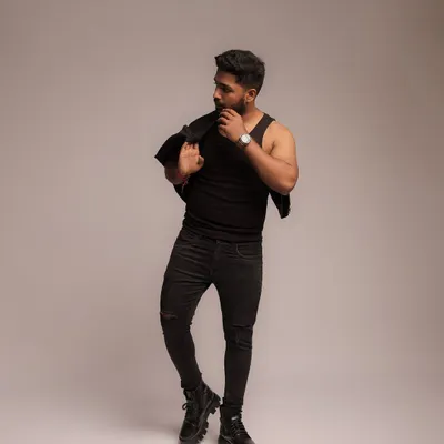A full-length fashion-style portrait against a clean studio background. This type of image is perfect for building a fitness influencer's brand, showcasing style and presence along with a strong physique.