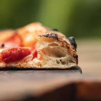 Look at that crumb structure. This cross-section of our sourdough crust shows the airy, open texture that comes from a long, 72-hour fermentation process. It's light, digestible, and delicious.