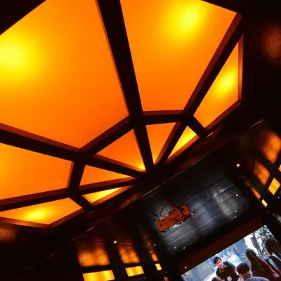 A close-up of a custom geometric ceiling light fixture with warm, diffused light. This type of architectural lighting adds a unique and sophisticated design element to any home theater.