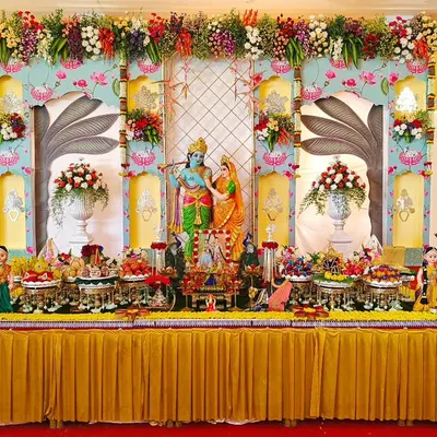 A specialized traditional plate decoration for an engagement, featuring a stunning backdrop with Radha and Krishna idols. The entire setup is a vibrant celebration of love and devotion.