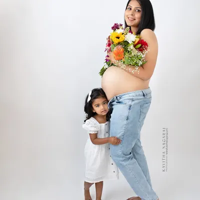 A mother-to-be and her daughter share a quiet moment of anticipation. Including older siblings in maternity shoots makes the memory even more special for the whole family.