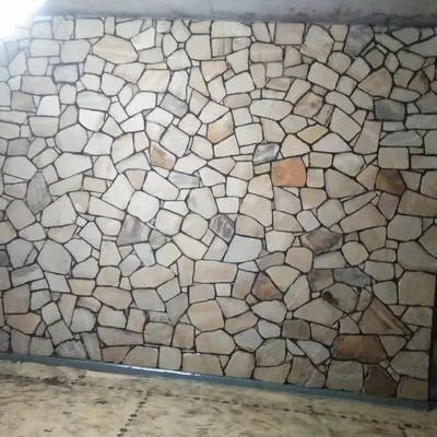 A full interior wall covered in light-colored, random-pattern stone cladding. This creates a stunning, rustic feature wall.