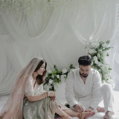 A tender moment between the couple, set against a backdrop of cascading white wisteria and soft, flowing drapes. This image perfectly captures the love and serenity of the day.