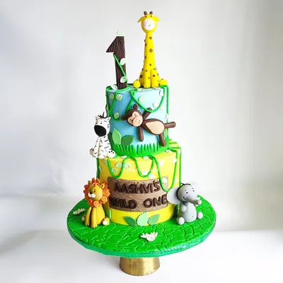 A wild and wonderful jungle theme for Aashvi's first birthday! This 3kg eggless chocolate truffle cake is two tiers of fun, with handcrafted fondant animals like a giraffe, monkey, zebra, lion, and elephant.