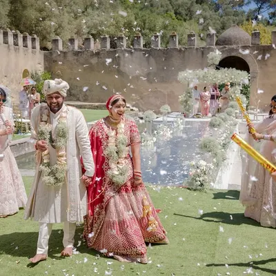Bhakti and Pratham after their sunset pheras, showered with confetti. This joyful moment captures the celebration and happiness of being newly married.