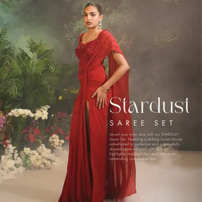 A full-length view of the Stardust Saree Set, showcasing its dramatic flow and elegant drape. The thigh-high slit adds a modern, confident touch to this classic red ensemble, perfect for cocktail parties and formal events.