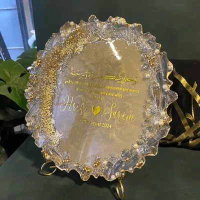 A beautiful resin engagement plaque designed to celebrate a new union. This piece features the couple's names, their special date, and a Quranic verse, all set in a shimmering gold and pearl design with a geode-style edge.